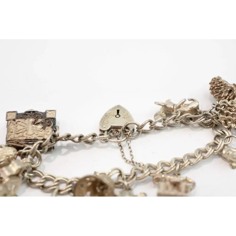 Gold charm bracelet with various charms on a white background