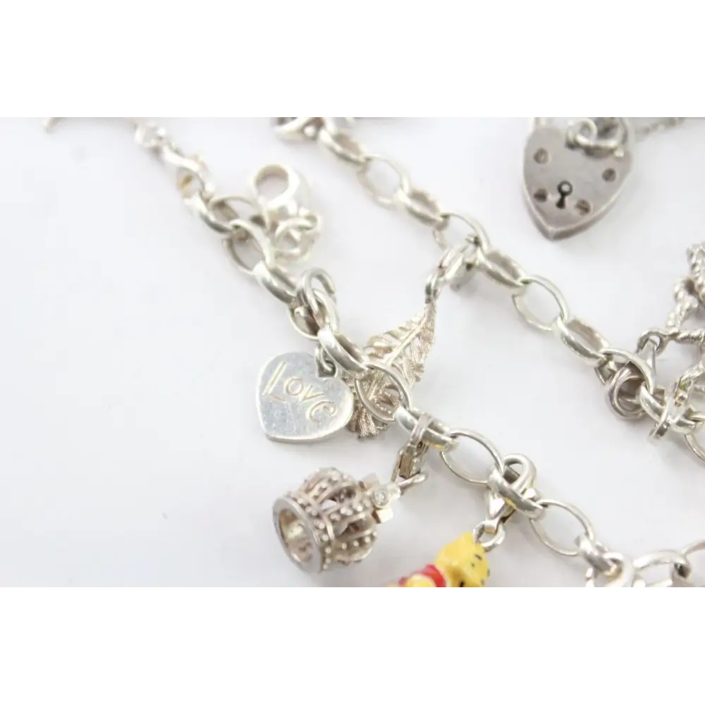Silver bracelet with various charms on a white background