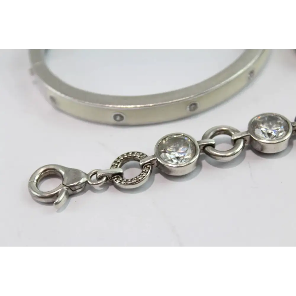 Silver bracelet with clear gemstones on a white background