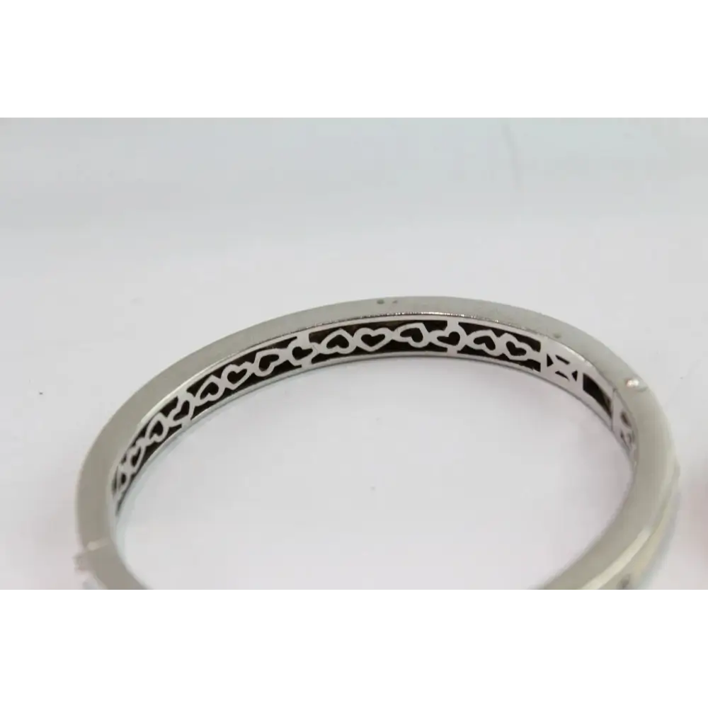 Silver bracelet with intricate design on a white background