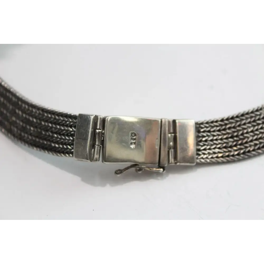 Silver mesh bracelet with a clasp on a white background