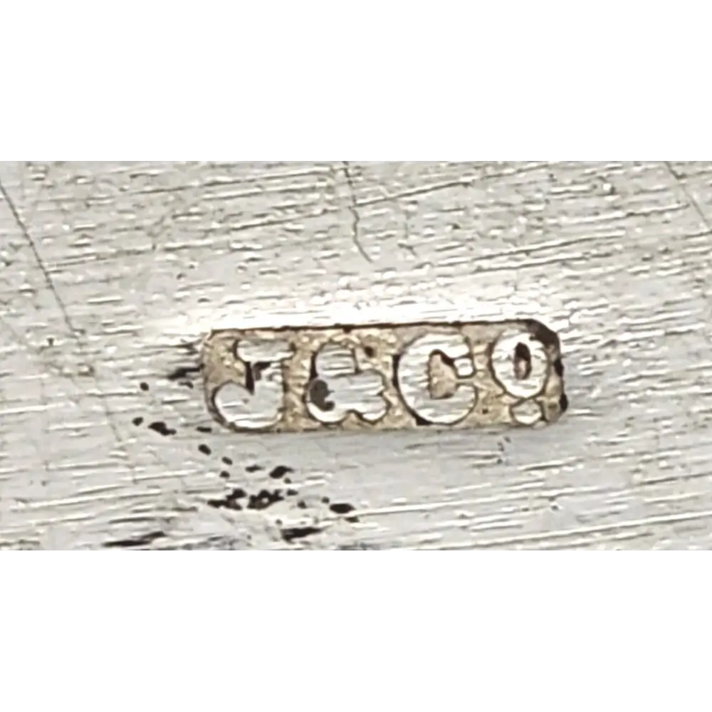 Close-up of a silver metal stamp with 'J & Co' engraving