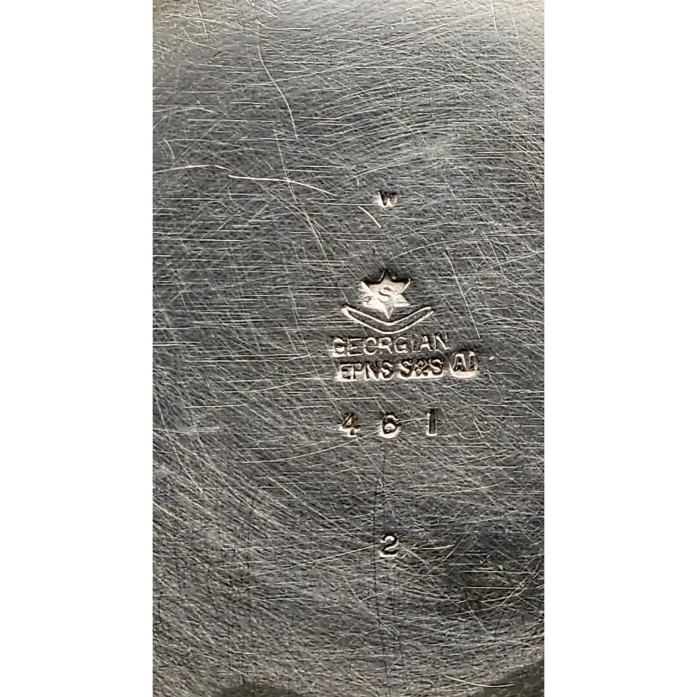 Close-up of a silver object with 'Georg Jensen' branding