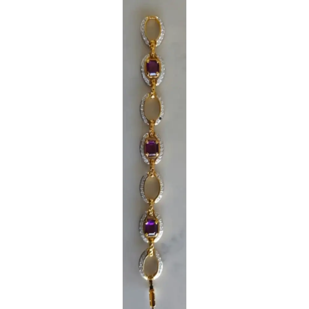 Gold bracelet with purple gemstones on a white background