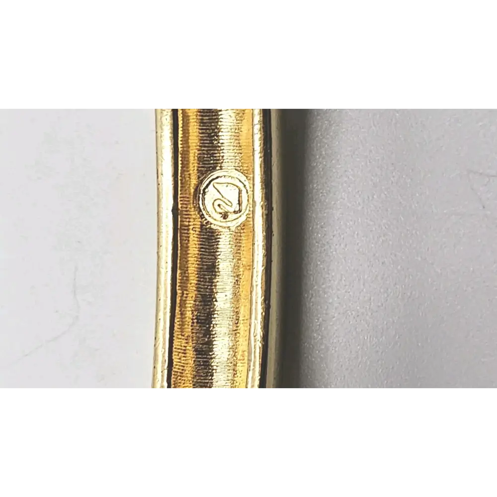 Close-up of a gold pen with a brand logo