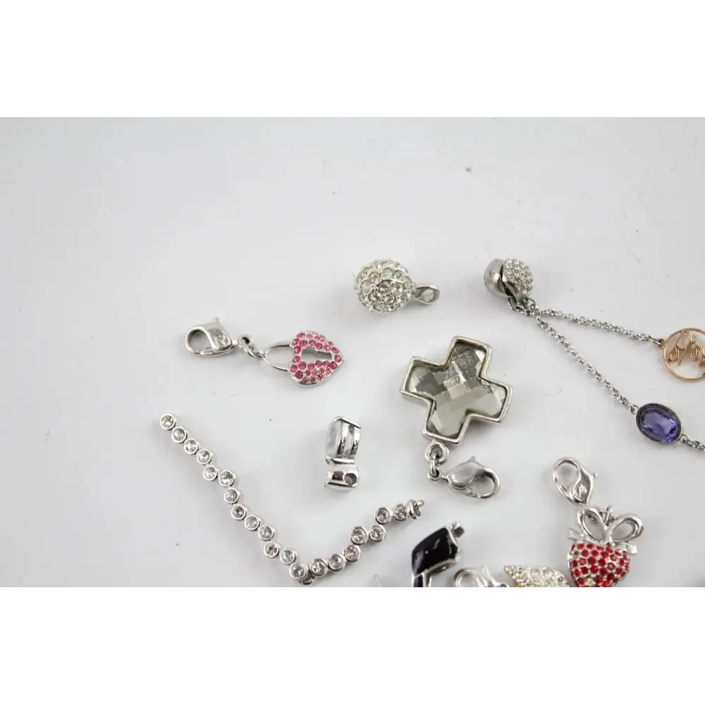 Collection of various jewelry charms on a light gray background