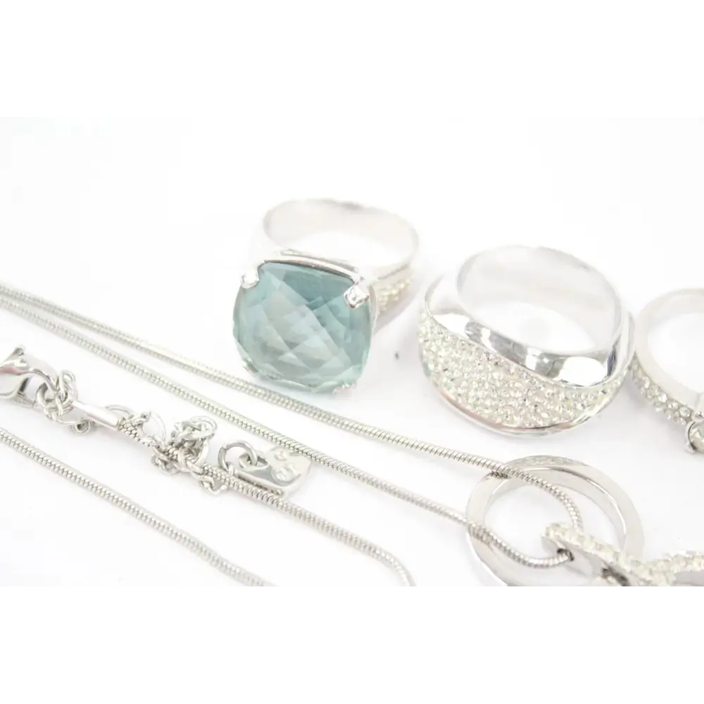 Silver jewelry set with a pendant and chain on a white background