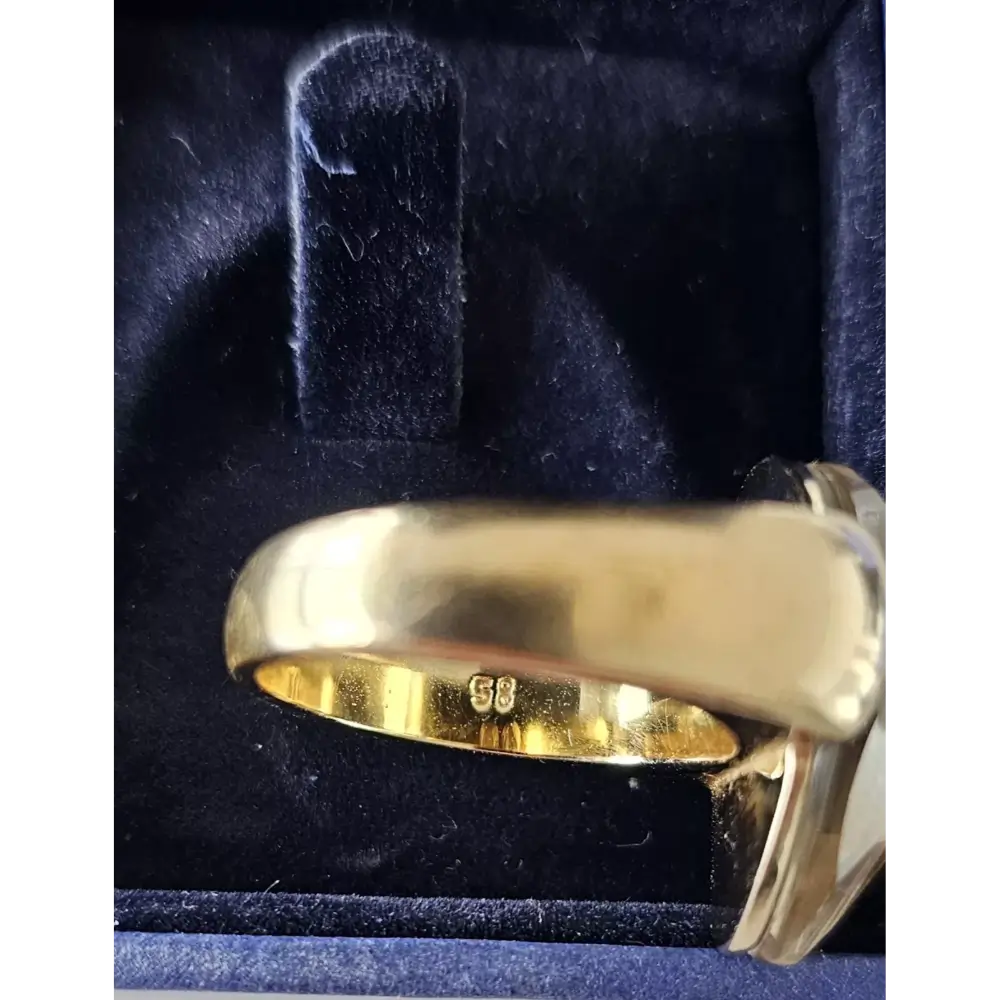 Gold ring with a diamond on a blue velvet background