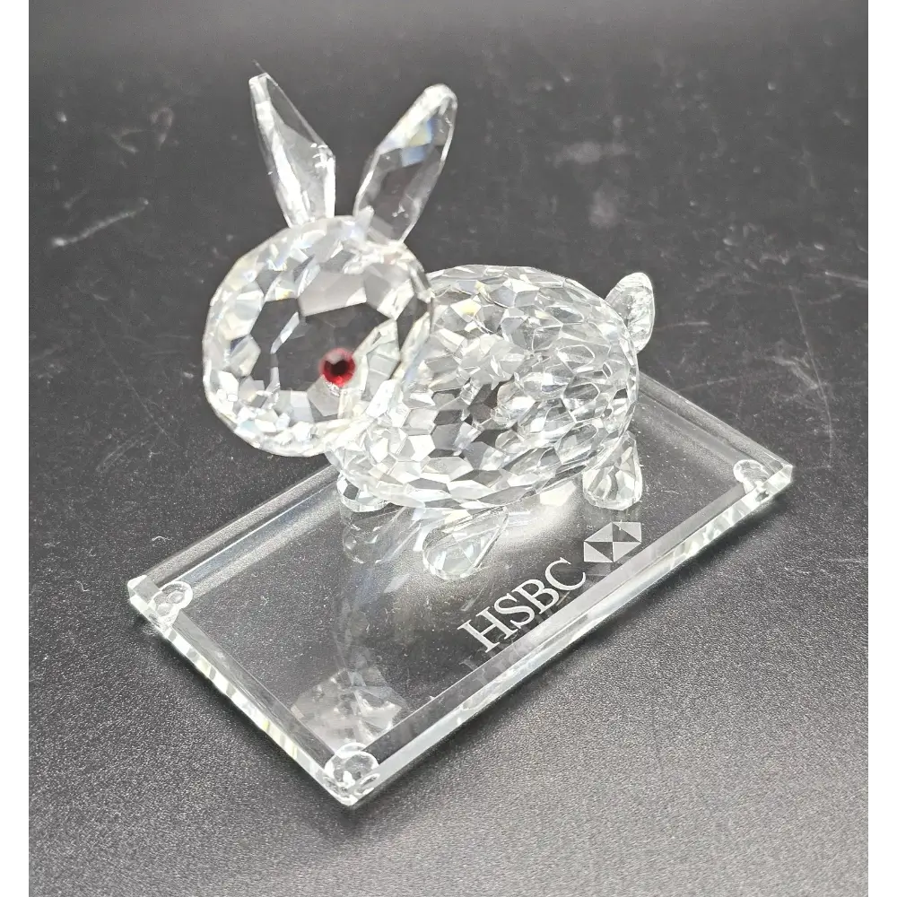 Crystal rabbit figurine on an HSBC branded stand against a dark background