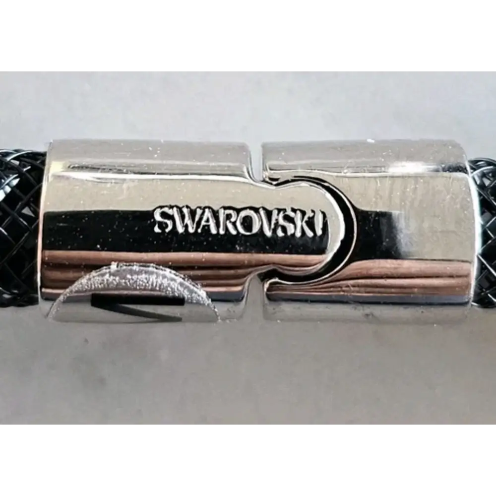 Swarovski branded bracelet clasp on a light gray background