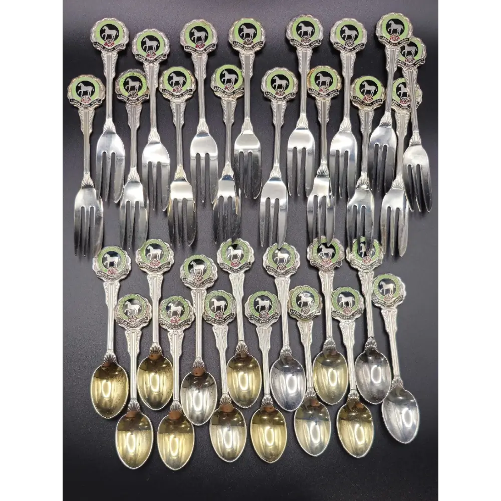 Set of silver flatware with decorative handles on a dark background