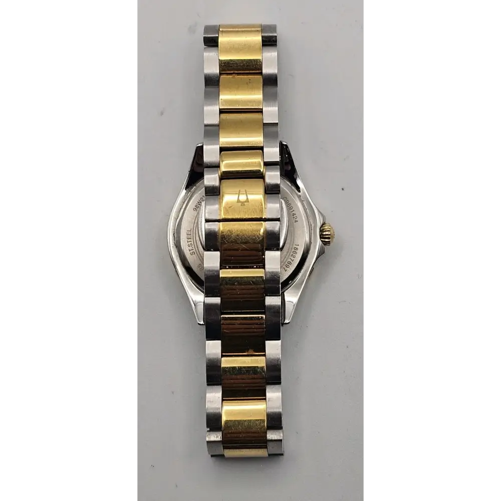 Two-tone watch with gold and silver band on a gray background