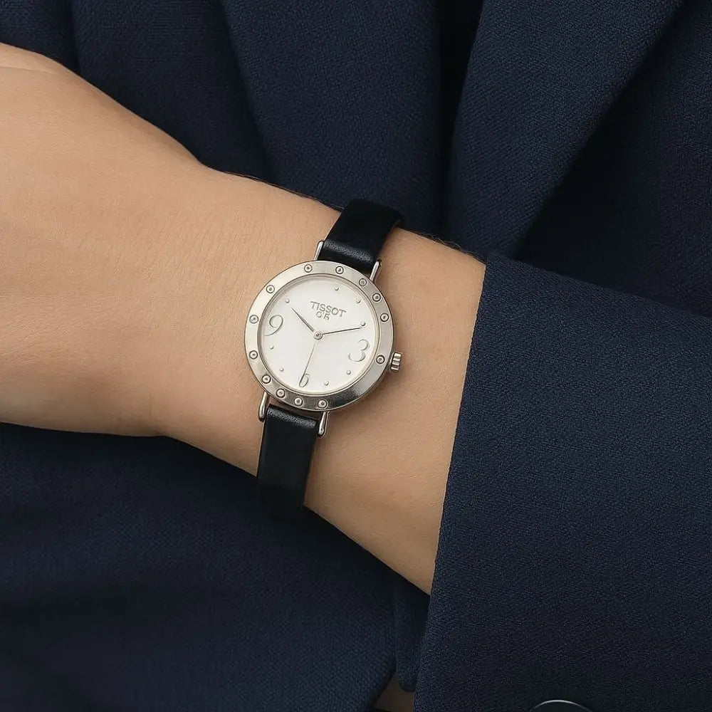 Wrist wearing a watch with a black strap and silver case