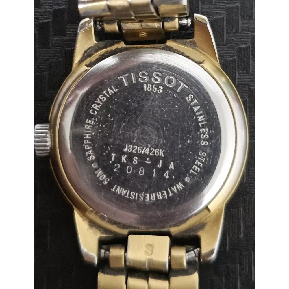 Back view of a Tissot watch with visible branding and model number.