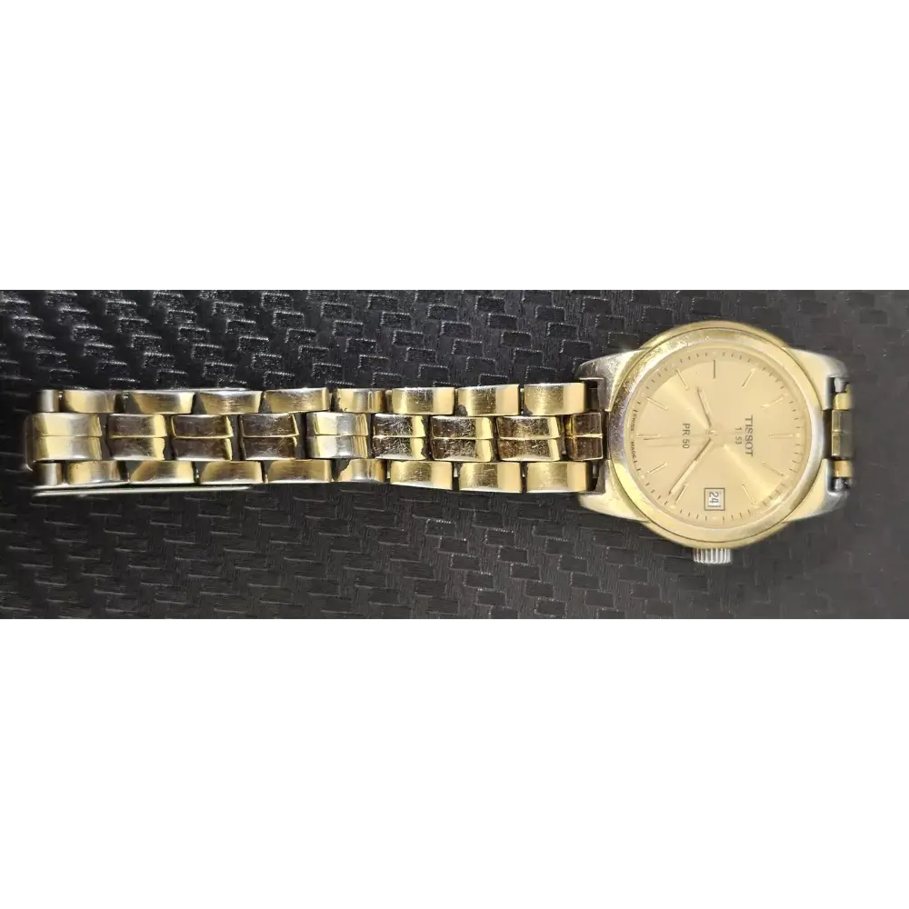 Gold wristwatch on a black textured background