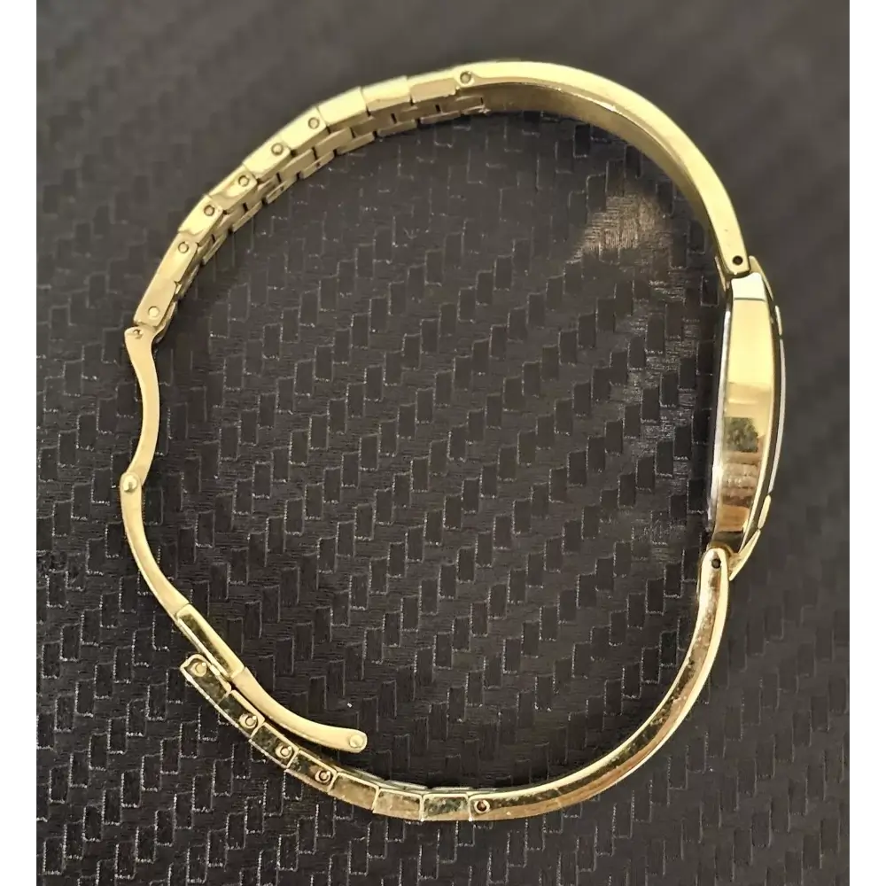 Gold watch on a textured black background