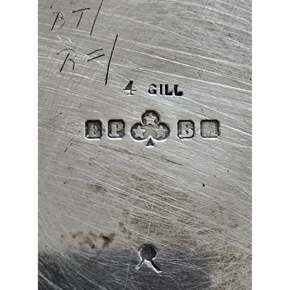 Close-up of a silver object with engraved text and symbols