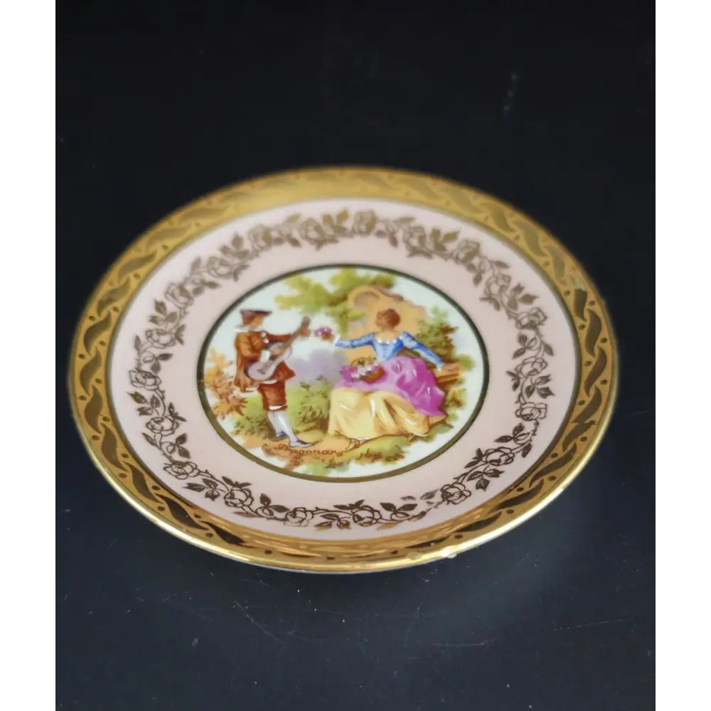 Decorative plate with a painted scene of two people and decorative border