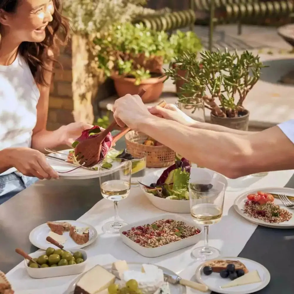 Two people enjoying a meal outdoors with plates