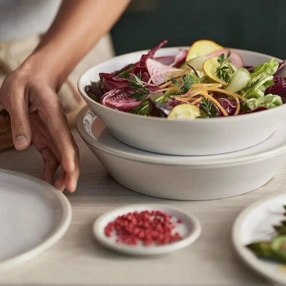 Person reaching for a bowl of salad