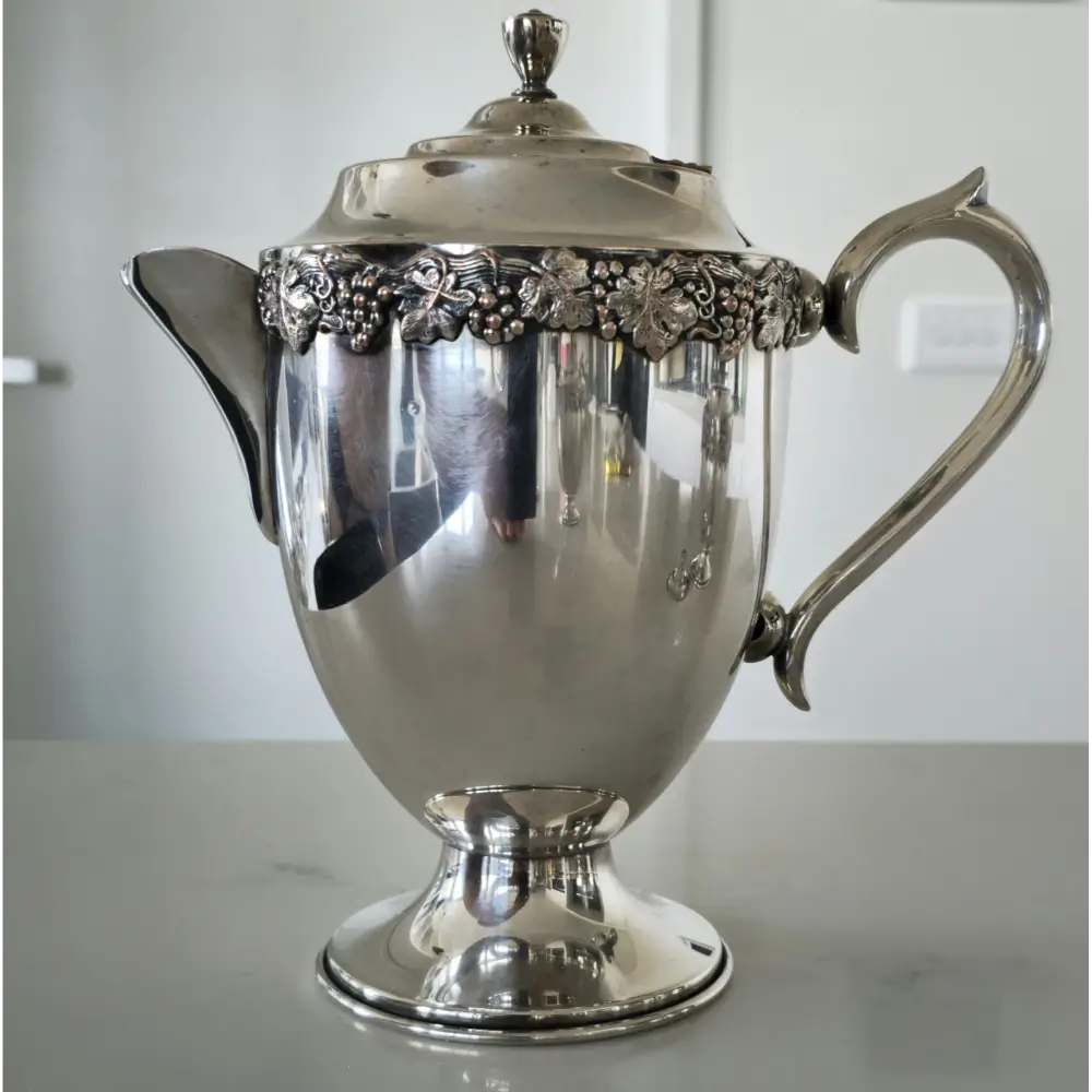 Side view of vintage 5-piece silver plated tea set showing teapot and sugar bowl