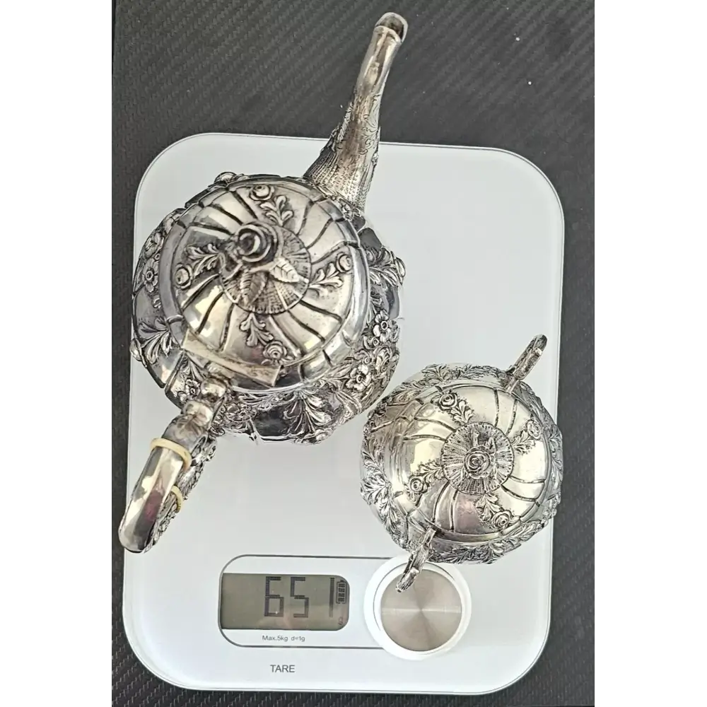 Decorative silver teapots on a digital scale