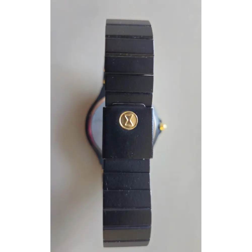 Black wristwatch with a gold emblem