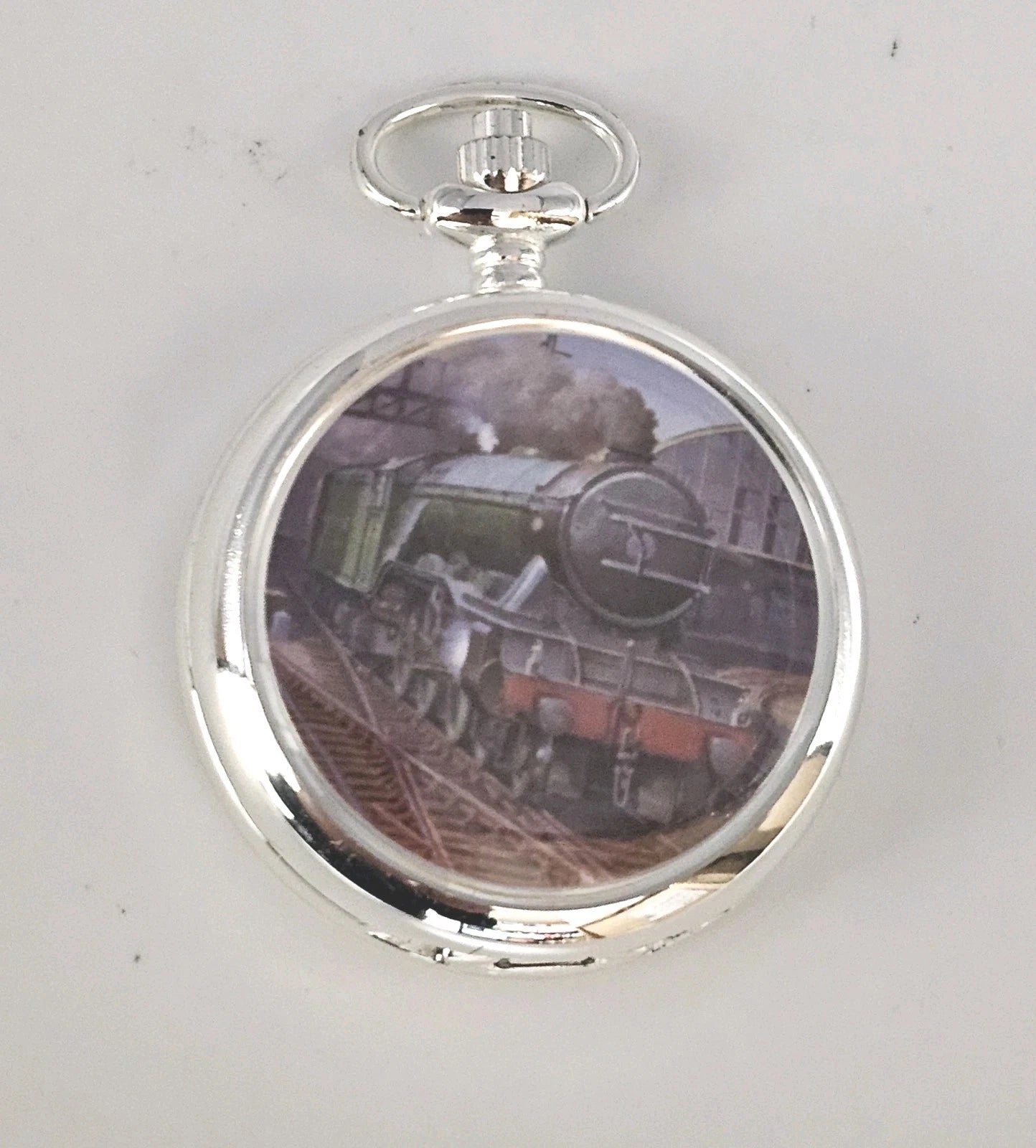Silver pocket watch with a train design on the face