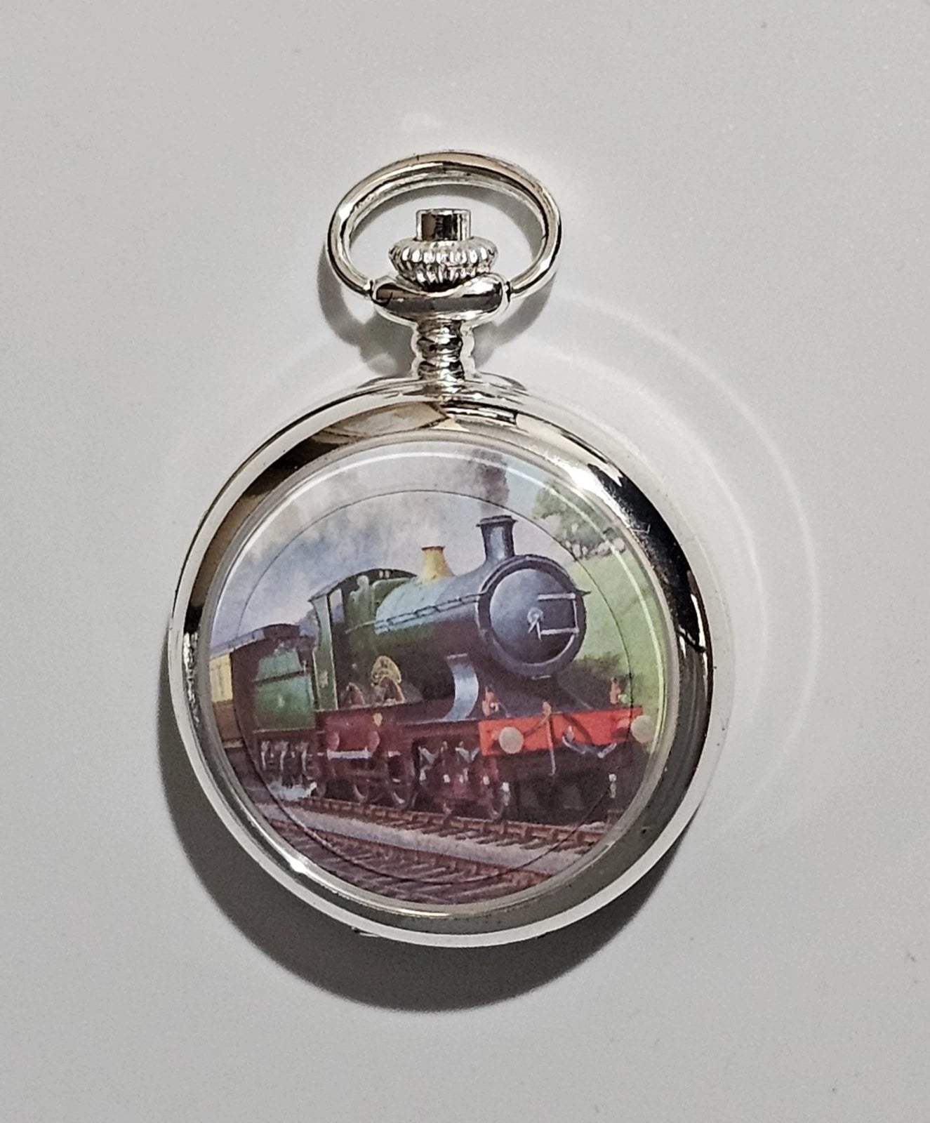 Pocket watch with a train design on the face against a white background