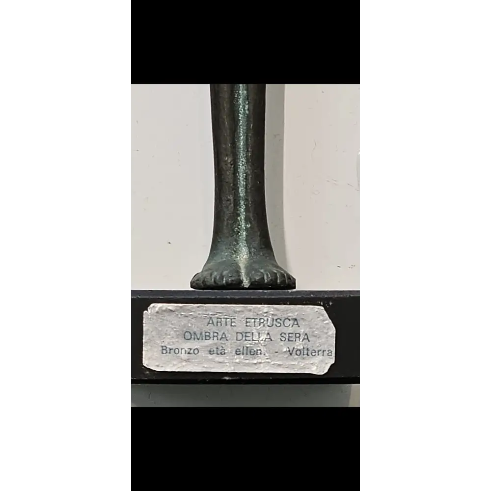 Bronze statue with a label on a white background