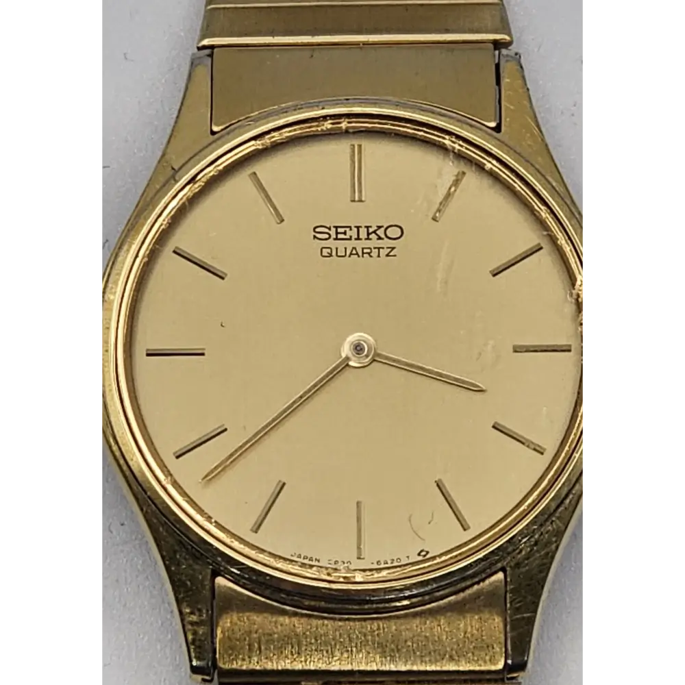 Gold Seiko quartz watch on a gray background