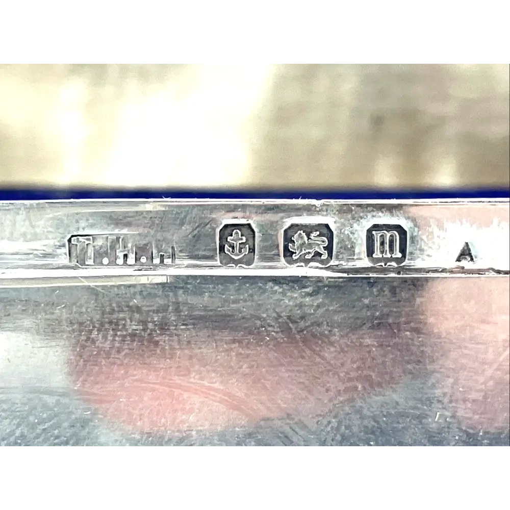Close-up of a silver object with engraved marks on a reflective surface