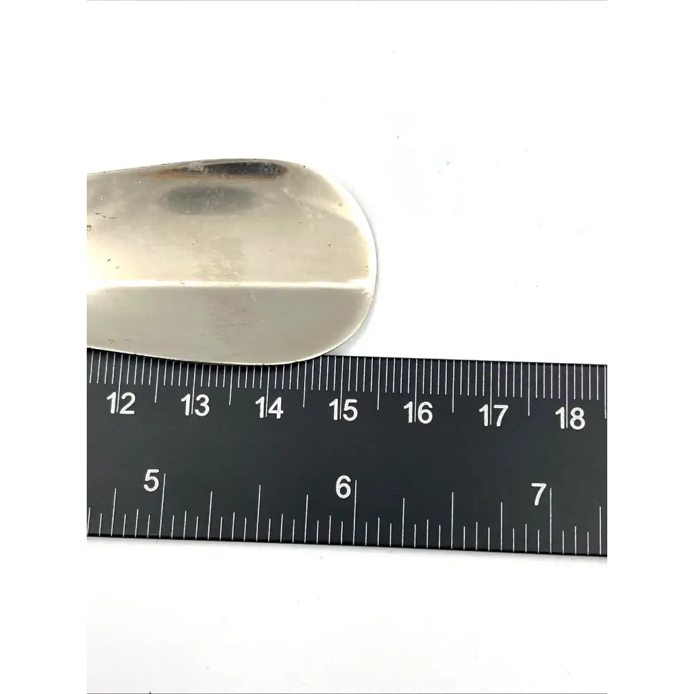 Metallic object next to a ruler