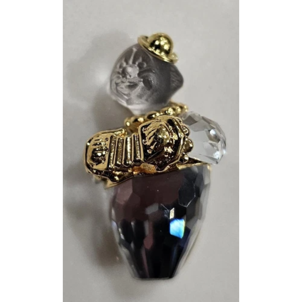 Decorative object with gold accents, clear crystal, and dark purple gem