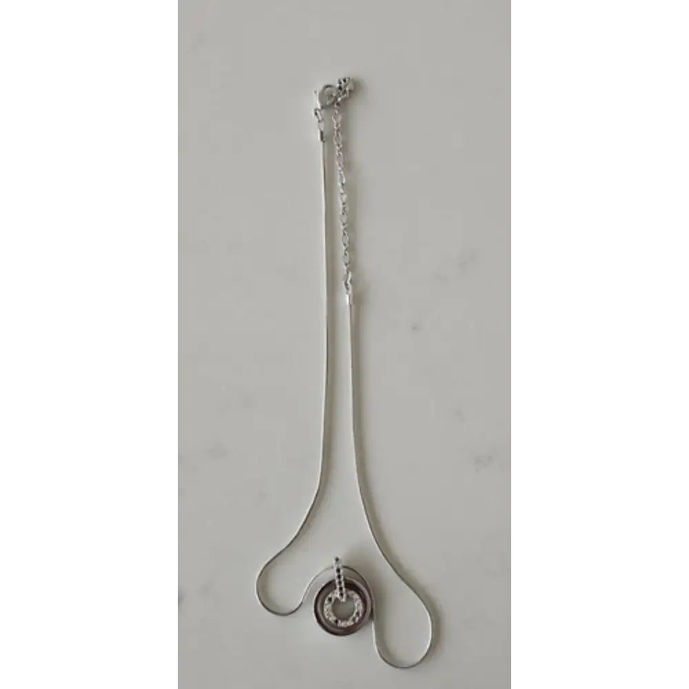 Silver necklace with a pendant on a light gray background
