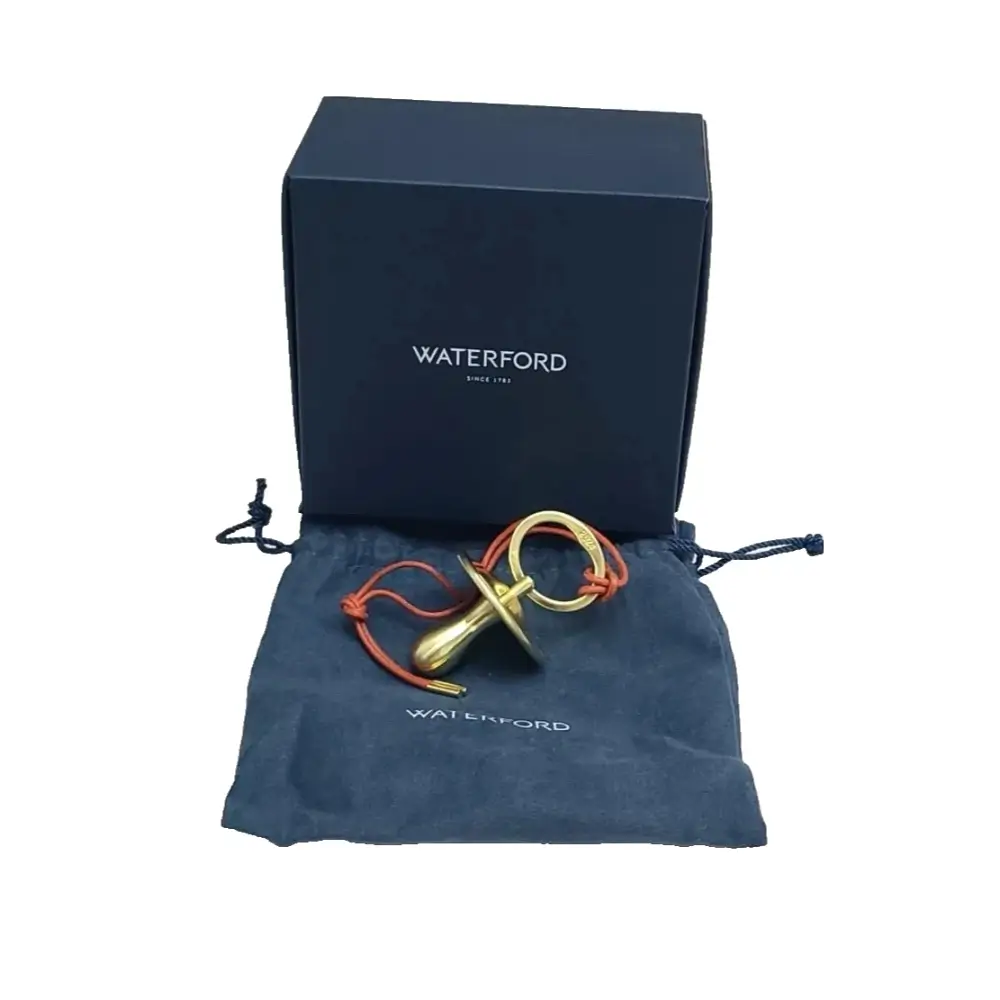 Gold and red object on a Waterford branded pouch with a Waterford box in the background.