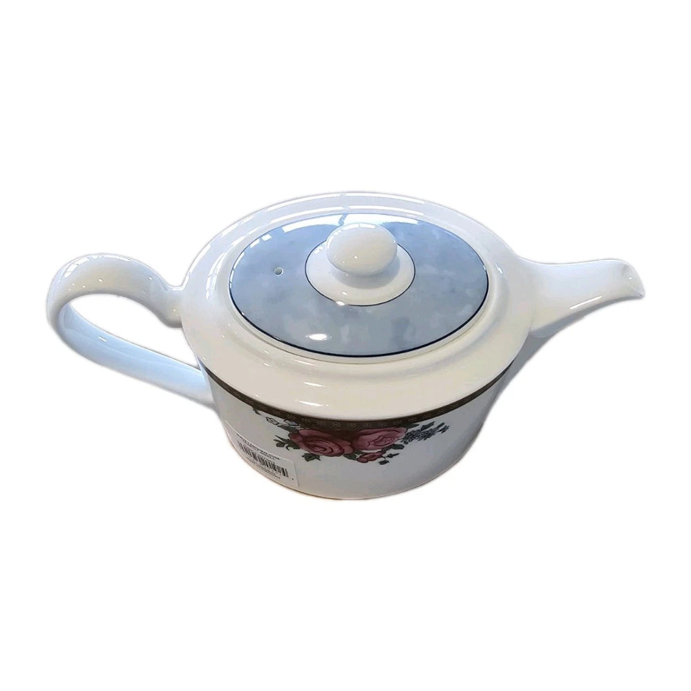 White ceramic teapot with floral design on a white background