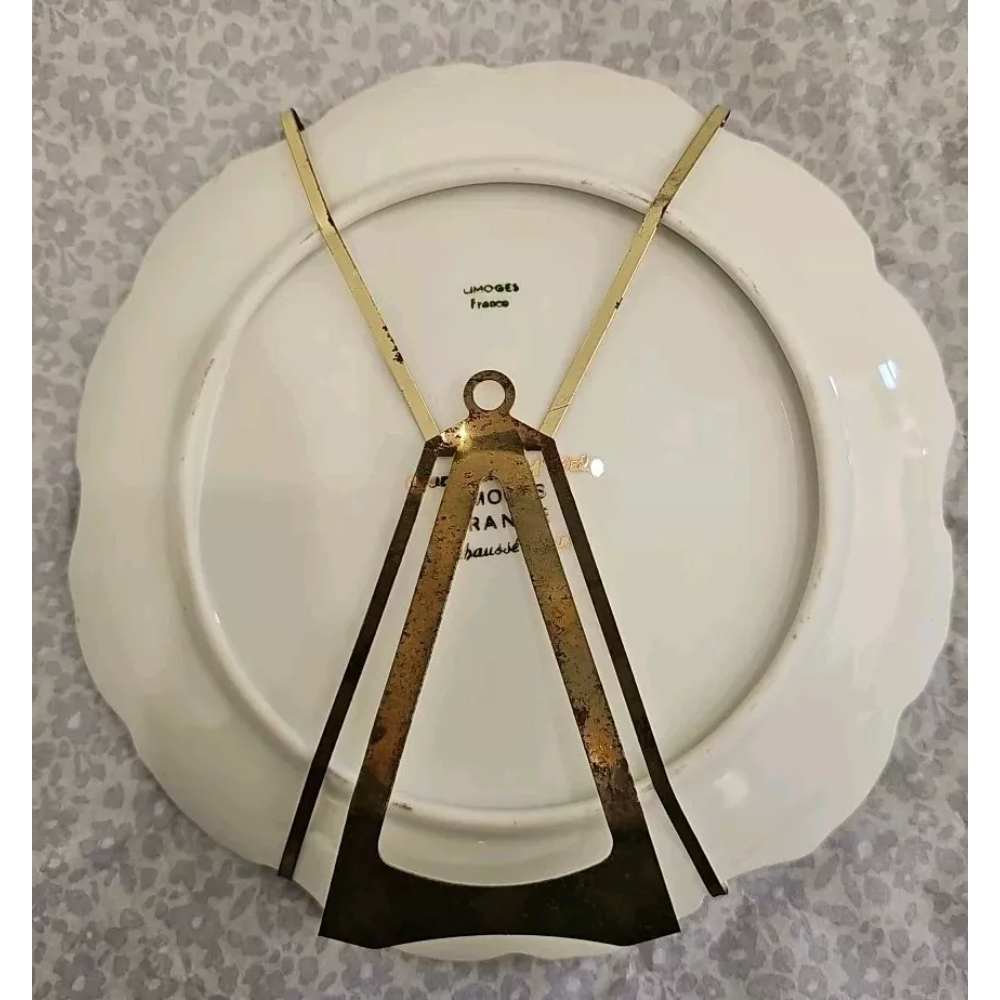 White plate with gold and black design on a gray background