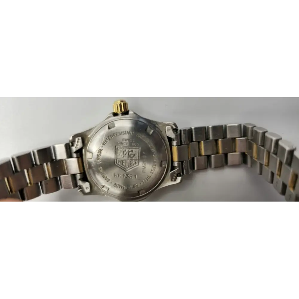 Close-up of a silver watch with a visible brand logo