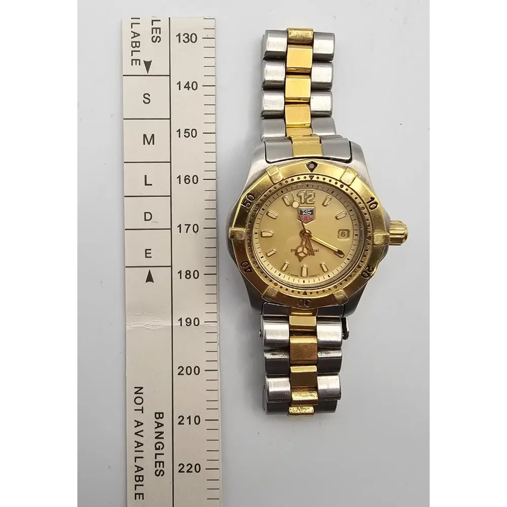 Gold and silver watch next to a size chart