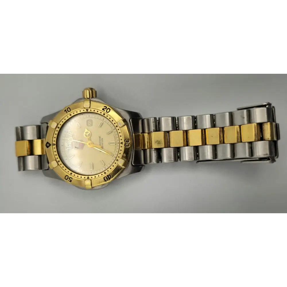 Gold and silver watch on a gray background