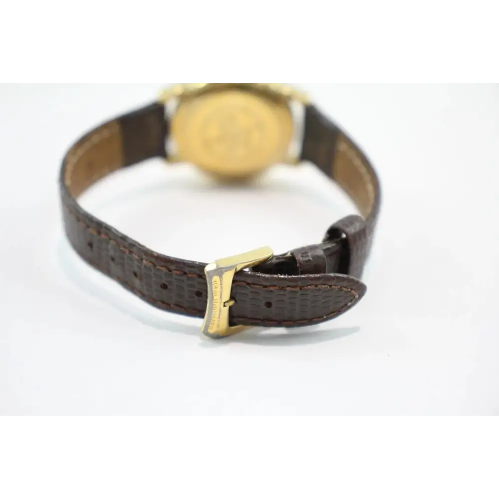 Watch with a brown leather strap and gold buckle