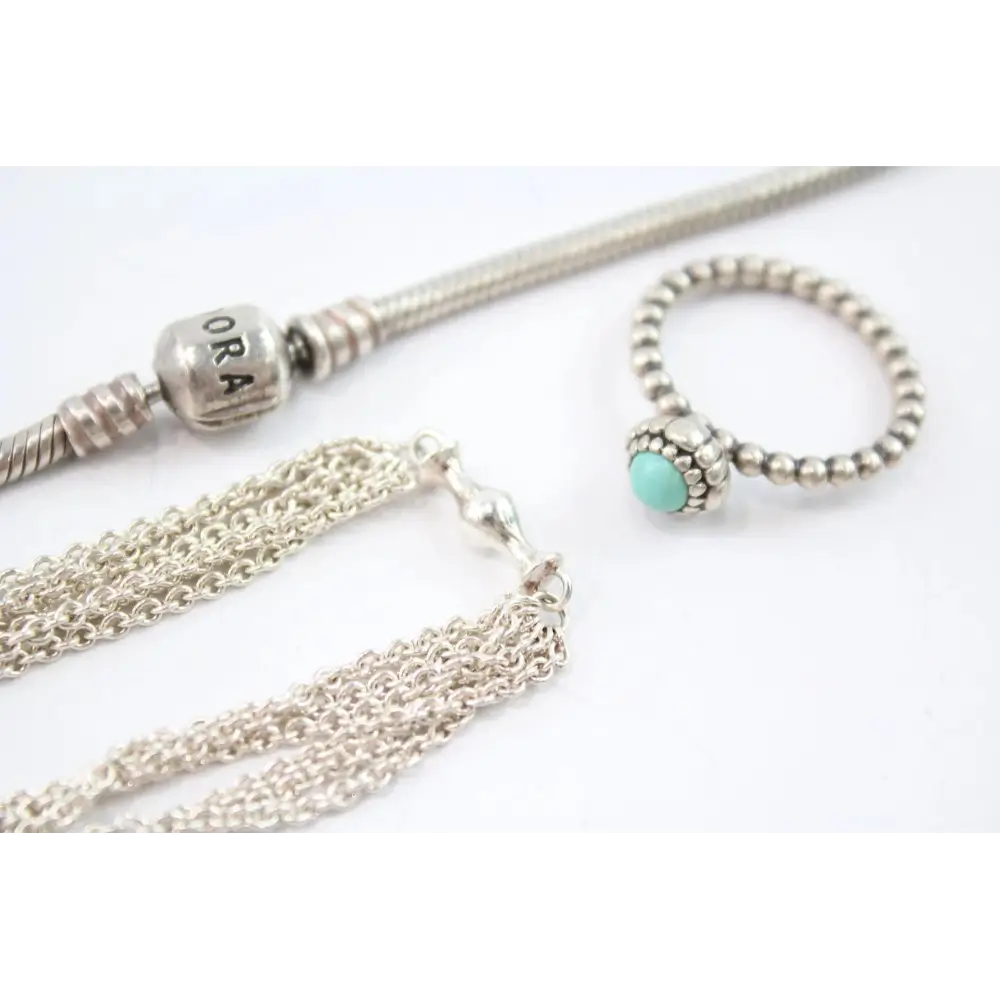 Silver necklace with tassel and turquoise bead on a white background
