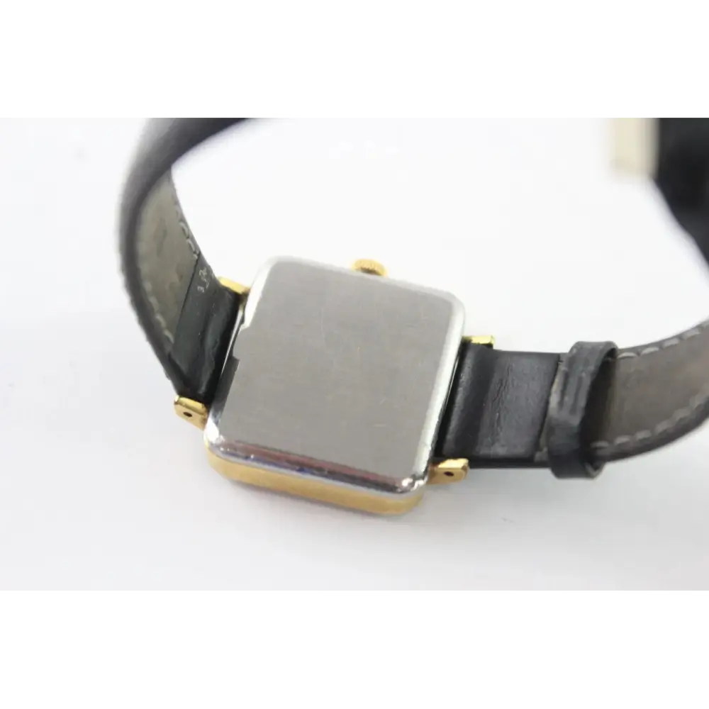 Black leather strap with a silver and gold watch buckle
