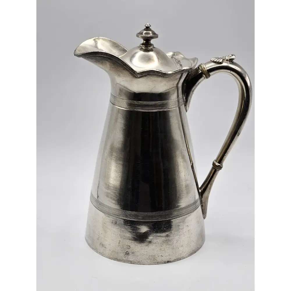 Silver pitcher on a light gray background