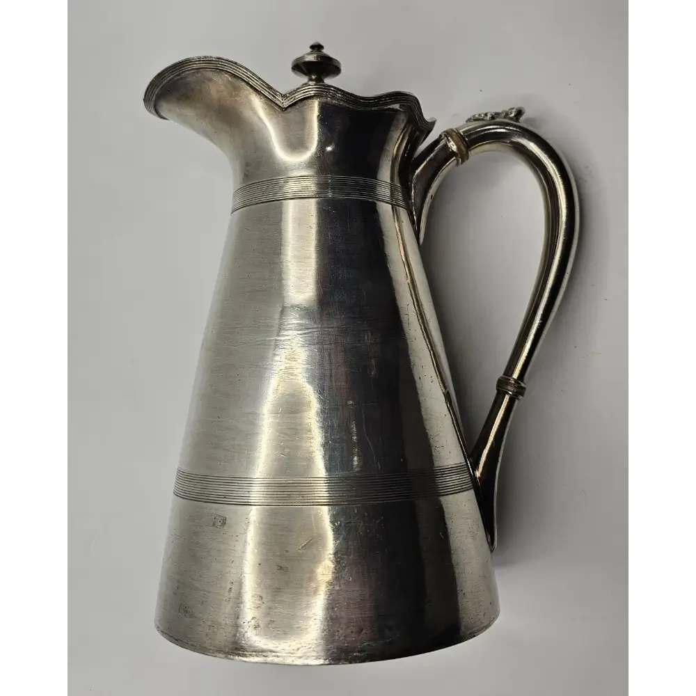 Silver pitcher on a gray background