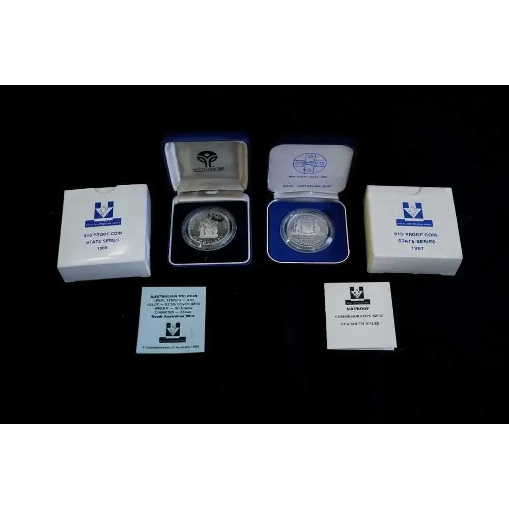 Two silver coins in display cases with certificates on a black background