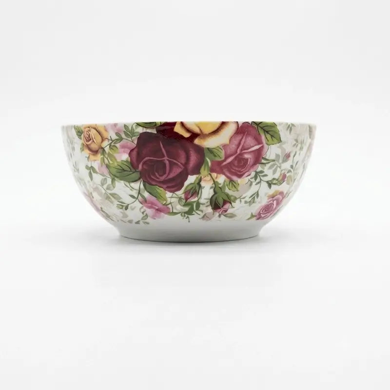 A white ceramic bowl decorated with a vintage-style floral pattern featuring dark red, pink, and yellow roses with green leaves, set against a plain white background.