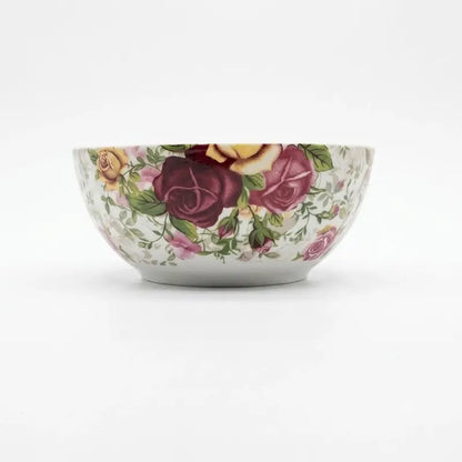 A white ceramic bowl decorated with a vintage-style floral pattern featuring dark red, pink, and yellow roses with green leaves, set against a plain white background.