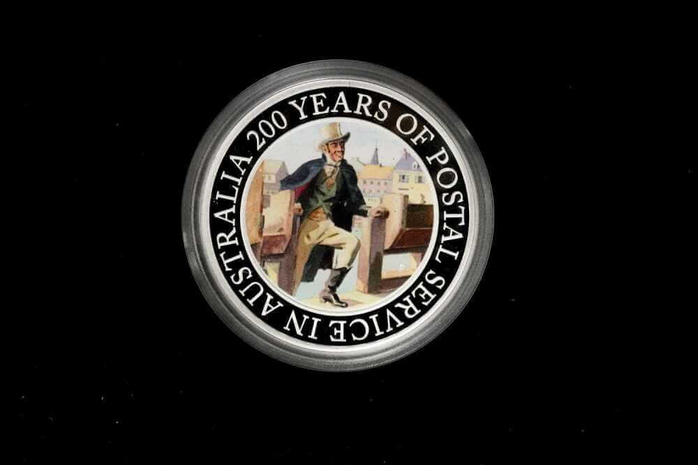 A circular commemorative coin or medallion on a black background, featuring a vintage illustration of a postal worker and the text 'AUSTRALIA 200 YEARS OF POSTAL SERVICE IN AUSTRALIA' around the edge frpom our Gold Proof Sets & Commemorative Medals collection 